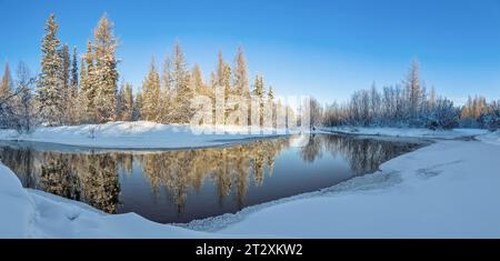 Winterlandschaft mit einem kleinen Fluss und Wald im Wasser, in Süd-Yakutien, Russland Stockfoto