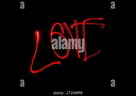 Hellrote Beschriftung mit der Freeze Light-Methode auf dem Foto zum Valentinstag, für Geschenke an Lieben. Stockfoto