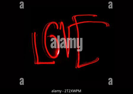 Hellrote Beschriftung mit der Freeze Light-Methode auf dem Foto zum Valentinstag, für Geschenke an Lieben. Stockfoto