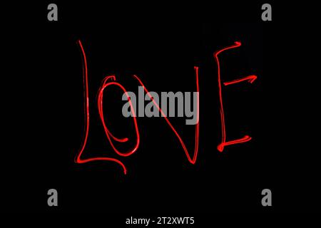 Hellrote Beschriftung mit der Freeze Light-Methode auf dem Foto zum Valentinstag, für Geschenke an Lieben. Stockfoto