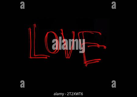Hellrote Beschriftung mit der Freeze Light-Methode auf dem Foto zum Valentinstag, für Geschenke an Lieben. Stockfoto