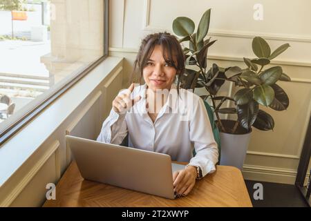 Mädchen-Persona kommuniziert in sozialen Netzwerken hinter einem Laptop. Stockfoto