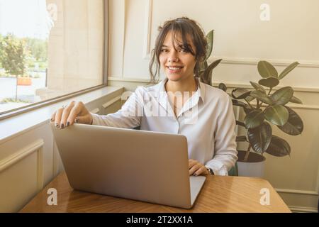 Mädchen-Persona kommuniziert in sozialen Netzwerken hinter einem Laptop. Stockfoto