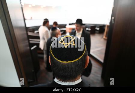 22. Oktober 2023, Sachsen-Anhalt, Dessau-Roßlau: Am Eingang des Gebetssaals steht ein Teilnehmer an der Einweihung der neuen Weill-Synagoge. Die Synagoge ergänzt das 1908 erbaute Rabbinerhaus, das heute unter Denkmalschutz steht und in dem Kurt Weill seine Kindheit verbrachte. Mit der Synagoge verfügt die Gemeinde heute über ein modernes, barrierefreies religiöses und kulturelles Zentrum. Foto: Hendrik Schmidt/dpa Stockfoto