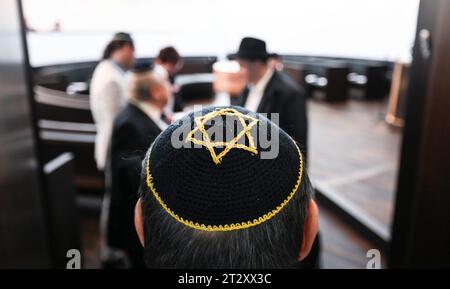 22. Oktober 2023, Sachsen-Anhalt, Dessau-Roßlau: Am Eingang des Gebetssaals steht ein Teilnehmer an der Einweihung der neuen Weill-Synagoge. Die Synagoge ergänzt das 1908 erbaute Rabbinerhaus, das heute unter Denkmalschutz steht und in dem Kurt Weill seine Kindheit verbrachte. Mit der Synagoge verfügt die Gemeinde heute über ein modernes, barrierefreies religiöses und kulturelles Zentrum. Foto: Hendrik Schmidt/dpa Stockfoto