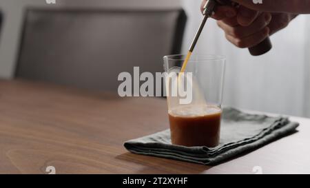 Nitro-Kaffee in dünnem Glas auf Walnusstisch machen, großes Foto Stockfoto