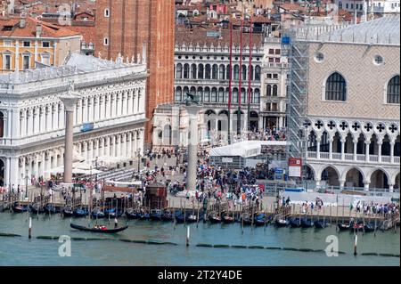 Touristen füllen die Piazza San Marco (Markusplatz) in der Nähe des Ufers der Lagune in Venedig in der Region Veneto in Italien. (Links) ist eine sechzehn Stockfoto