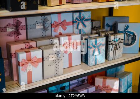 Bunte und gemusterte Geschenkboxen sind auf mehrstufigen Regalen angeordnet Stockfoto