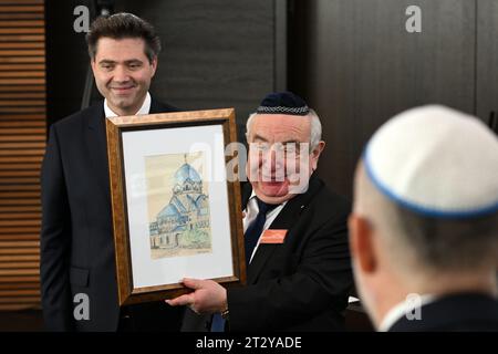 22. Oktober 2023, Sachsen-Anhalt, Dessau-Roßlau: Einweihung der neu errichteten Synagoge in Dessau-Roßlau überreicht Robert Reck (l, unabhängig), Bürgermeister der Stadt Dessau-Roßlau, Alexander Wassermann, Vorsitzender der Dessauer Jüdischen Gemeinde, eine Kopie einer historischen Zeichnung der alten Dessauer Synagoge. Die Synagoge ergänzt das 1908 erbaute Rabbinerhaus, das heute unter Denkmalschutz steht und in dem Kurt Weill als sein Vater Albert Weill Kantor der Gemeinde war. Das religiöse und kulturelle Leben der jüdischen Gemeinde in Dessau, die vor dreißig Jahren neu gegründet wurde, Stockfoto