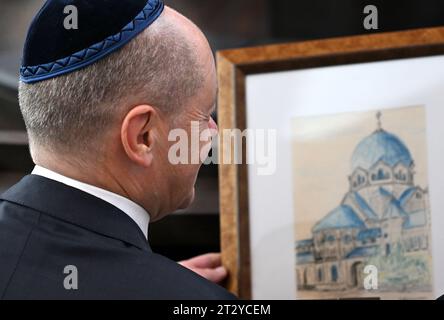 22. Oktober 2023, Sachsen-Anhalt, Dessau-Roßlau: Bundeskanzler Olaf Scholz (SPD) sieht sich eine Kopie einer historischen Zeichnung der alten Dessauer Synagoge an. Die Synagoge ergänzt das 1908 erbaute Rabbinerhaus, das heute unter Denkmalschutz steht und in dem Kurt Weill als sein Vater Albert Weill Kantor der Gemeinde war. Das religiöse und kulturelle Leben der vor dreißig Jahren neu gegründeten jüdischen Gemeinde in Dessau hat sich bisher auf dem sehr begrenzten Raum des Rabbinerhauses abgespielt. Mit der Weill Synagoge verfügt die Gemeinde heute über eine moderne, barrierefreie religiöse und Stockfoto