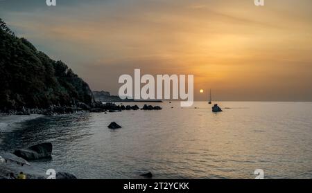 Sonnenuntergang am berühmten Michelino-Strand mit Nebel am Horizont, Parghelia - Tropea, Vibo Valentia, Kalabrien, Italien Stockfoto