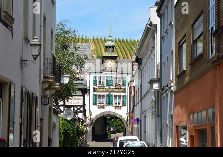 Ruedesheim, Deutschland - 29. Mai 2011: Enge Straße mit Gebäuden, Hotel und Uhrenturm im UNESCO-Weltkulturerbe Rheintal Stockfoto