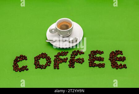 Espresso in einer kleinen Tasse mit Text Kaffee in Bohnen darunter Stockfoto