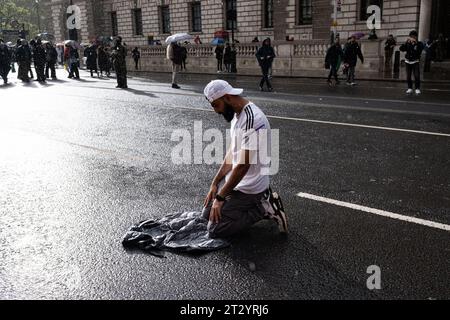 London, Großbritannien. Oktober 2023. Ein Demonstrant wird nach dem marsch im Regen in Westminster beten gesehen. Nach dem ersten märz am 7. Oktober nahmen etwa 100.000 pro-palästinensische Demonstranten, die von der Metropolitanpolizei angeklagt wurden, an einem marsch in Zentral-London Teil, um Solidarität mit Palästinensern zu zeigen und ein Ende der israelischen Bombardierung des Gazastreifens zu fordern. Die Demonstranten versammelten sich in Marble Arch und marschierten hinunter zum Parlamentsplatz. Quelle: SOPA Images Limited/Alamy Live News Stockfoto