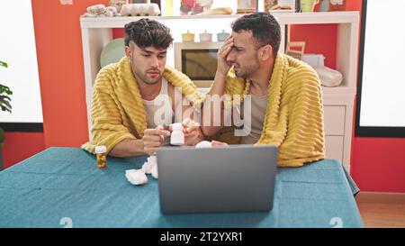 Zwei Männer, die ein medizinisches Online-Gespräch im Speisesaal haben Stockfoto