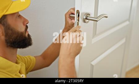 Junger hispano-Mann, der zu Hause eine Knopflose repariert Stockfoto