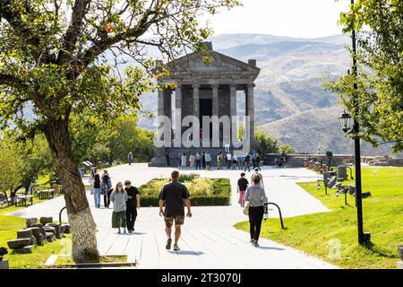 Garni, Armenien - 30. September 2023: Touristen gehen am sonnigen Herbsttag zum antiken griechisch-römischen Tempel von Garni in den Gegham-Bergen von Armenien Stockfoto