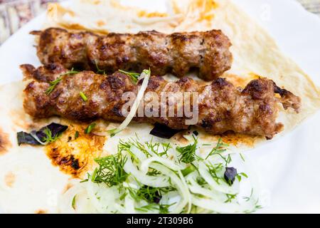 Ein Teil der Kebabs auf dem Teller in der Nähe im armenischen Dorf im Außenrestaurant Stockfoto