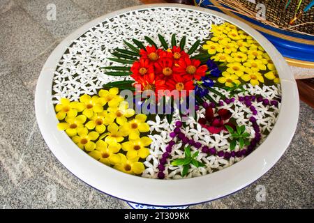 Sie bieten viele schöne Blumenblüten, die im Keramikbecken oder im glasierten Wasserglas schweben, Opfer für buddha und den heiligen Gott Engel des Krieges Kuiburi Tempel Stockfoto