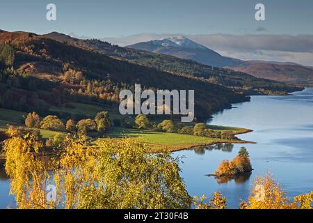 Queens View, in der Nähe von Pitlochry, Perth und Kinross, Schottland, Großbritannien. Oktober 2023. Das nach dem Sturm ruhige, herbstliche Laub scheint das jüngste stürmische Wetter überlebt zu haben, das außergewöhnlich starke Winde und sintflutartige Regenfälle brachte. Foto: Loch Tummel mit einem schneebedeckten Schiehallion-Berg im Hintergrund. Stockfoto