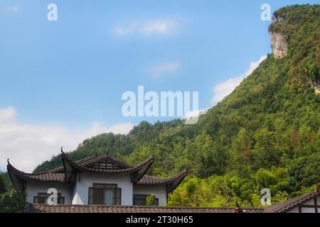 Erleben Sie den Reiz verschiedener Perspektiven, die traditionelle Häuser in harmonischer Weise in den bezaubernden chinesischen Wäldern präsentieren Stockfoto