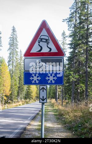 Schilder warnen vor Schnee und rutschigen Bedingungen in den Bergen der Dolomiten. Stockfoto