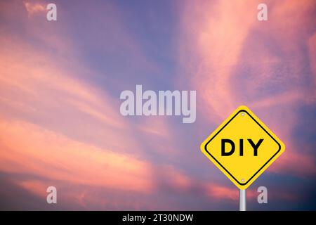 Gelbes Transportschild mit dem Wort DIY (Abkürzung für Do IT Yourself) auf violettem Hintergrund am Himmel Stockfoto