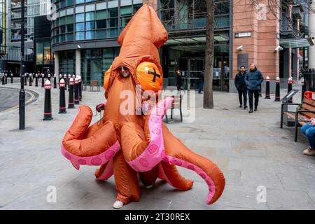 Eine junge Frau in einem Squid-Kostüm, die durch die City of London, London, Großbritannien läuft. Stockfoto