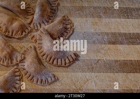 Traditionelle italienische Ravioli. Hausgemachte italienische Pasta. Frische Ravioli auf Holzbrett, Blick von oben Stockfoto