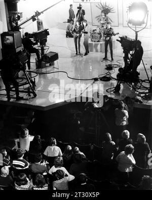 DIE BEATLES PAUL McCartney GEORGE HARRISON RINGO STARR und JOHN LENNON am Set Candid während der Dreharbeiten im Scala Theatre für Konzert-Finalszene und Publikum für A HARD DAY's NIGHT 1964 Regisseur RICHARD LESTER Walter Shenson Films / Proscenium Films / United Artists Stockfoto