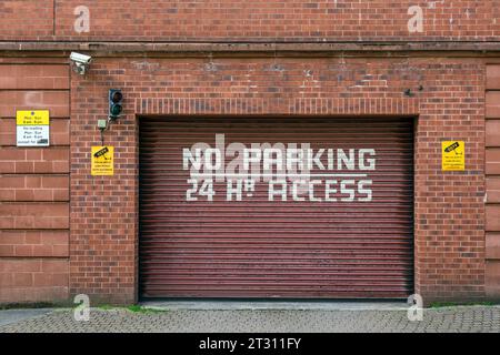 Kein Parken rund um die Uhr, Schild mit Zugang an einem Garagentor Stockfoto