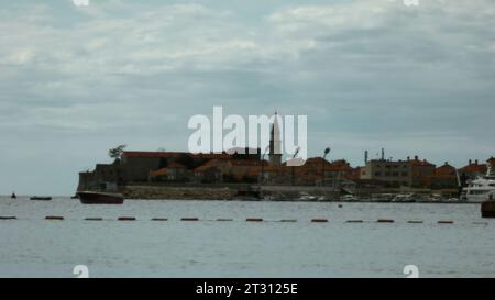 Wunderschöne Sommerhalbinsel und plätscherndes Meer. Kreativ. Turm und kleine Häuser auf bewölktem Himmel Hintergrund. Stockfoto