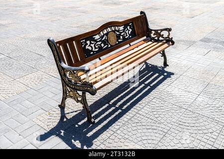 Jerewan, Armenien - 14. September 2023: Holzbank im Freien mit Jerewan-Wappen auf der Abovyan-Straße in Jerewan am sonnigen Herbsttag. Yereva Stockfoto