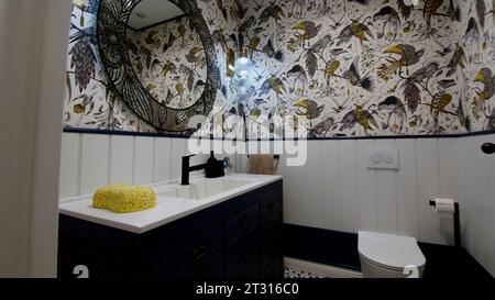Modernes Badezimmer mit Innenausstattung. Kreativ. Weiße Wandfliesen mit Blumenmuster und Vögeln. Stockfoto