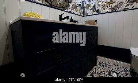 Modernes Badezimmer mit Innenausstattung. Kreativ. Weiße Wandfliesen mit Blumenmuster und Vögeln. Stockfoto