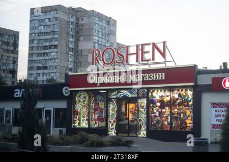 Odessa, Ukraine. Oktober 2023. Eine Filiale des Süßwarengeschäfts „Roshen“, im Besitz des ehemaligen ukrainischen Präsidenten Petro Poroschenko, leuchtet vor einem Wohnblock. Quelle: Sebastian Gollnow/dpa/Alamy Live News Stockfoto