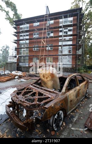 Irpin, Ukraine. Oktober 2023. Ein ausgebranntes Auto steht vor einem Haus, umgeben von Gerüsten. Die Stadt in der Nähe von Kiew wurde durch schwere Kämpfe teilweise zerstört. In der Zwischenzeit hat der Wiederaufbau Fortschritte gemacht. Quelle: Sebastian Gollnow/dpa/Alamy Live News Stockfoto