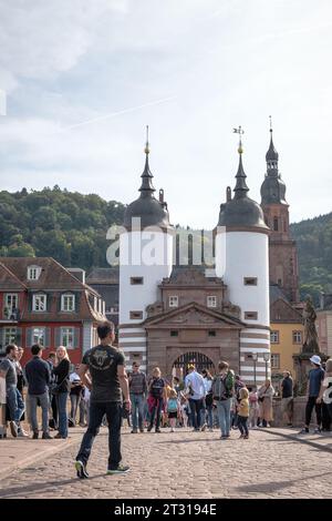 Viele Menschen laufen auf der alten Brücke der deutschen Stadt Heidelberg. Stockfoto