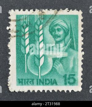 Gestempelte Briefmarke, gedruckt von Indien, die Farmer- und Landwirtschaftssymbole zeigt, um 1980. Stockfoto