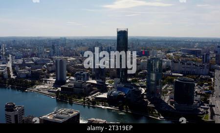 Luftaufnahme eines Stadtzentrums an einem Sommertag. Archivmaterial. Gebäude und Fluss, grüne Straßen. Stockfoto