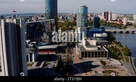Luftaufnahme eines Stadtzentrums an einem Sommertag. Archivmaterial. Gebäude und Fluss, grüne Straßen. Stockfoto