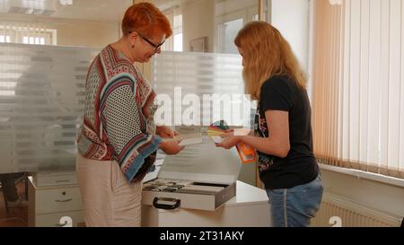 Deutschland - Berlin, 20. Mai 2023: Auswahl von Farbpaletten für Reparaturen. Kreativ. Frauen holen Farbpaletten für Reparaturen im Büro ab. Konstruktionsbüro für Stockfoto