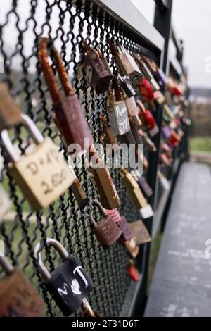 Viele Vorhängeschlösser auf dem Geländer der Fußgängerbrücke. Vorhängeschlösser symbolisieren Liebesbeziehungen. Stockfoto