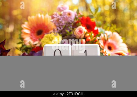 22. Oktober 2023: Kalenderwürfel mit einem Blumenstrauß in einem sonnigen Wald, Gruß an Allerheiligen Tag am 1. November FOTO-MOUNT *** Kalenderwürfel mit einem Blumenstrauß in einem sonnigen Wald, Gruß zu Allerheiligen am 1. November FOTOMONTAGE Credit: Imago/Alamy Live News Stockfoto