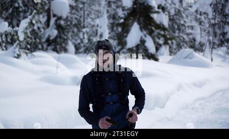 Wintersport. Clip. Männer in Sportuniformen mit Zahlen, die bei Wettkämpfen durch den Schnee laufen. Stockfoto