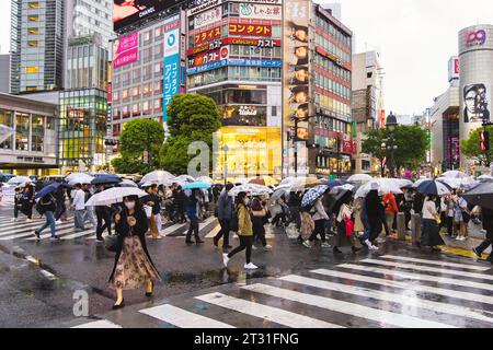 Tokio, Japan - 08. April 2023: Menschenmenge mit Regenschirmen an der Shibuya-Kreuzung mit nicht identifizierten Menschen. Es ist der meistbesuchte Fußgängerübergang der Welt. Stockfoto