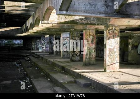 St. Peter's Semenary auf dem Anwesen Kilmahew in der Nähe von Cardross, Dumbarton, Schottland. Ein brachliegendes, brutalistisches Betongebäude in Wäldern, das mit Graffiti bedeckt ist Stockfoto