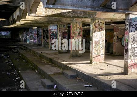 St. Peter's Semenary auf dem Anwesen Kilmahew in der Nähe von Cardross, Dumbarton, Schottland. Ein brachliegendes, brutalistisches Betongebäude in Wäldern, das mit Graffiti bedeckt ist Stockfoto