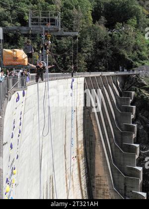 Contra Dam, Schweiz - 22. Oktober 2023: Bunging springt vom Damm, 'das Schild zeigt den Namen der vorgeschlagenen Aktivität' Stockfoto