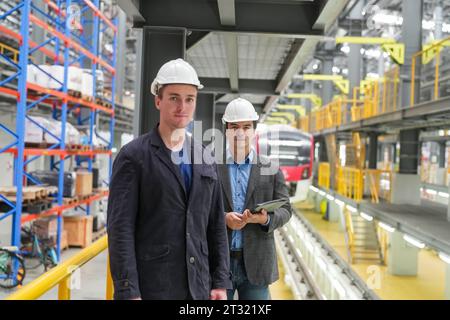 Porträt von Ingenieur und Lehrling in der Werkstatt der Eisenbahntechnik Stockfoto